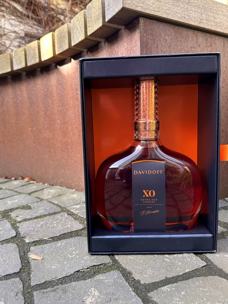 Eine Flasche Davidoff XO Cognac vor einer Bank.