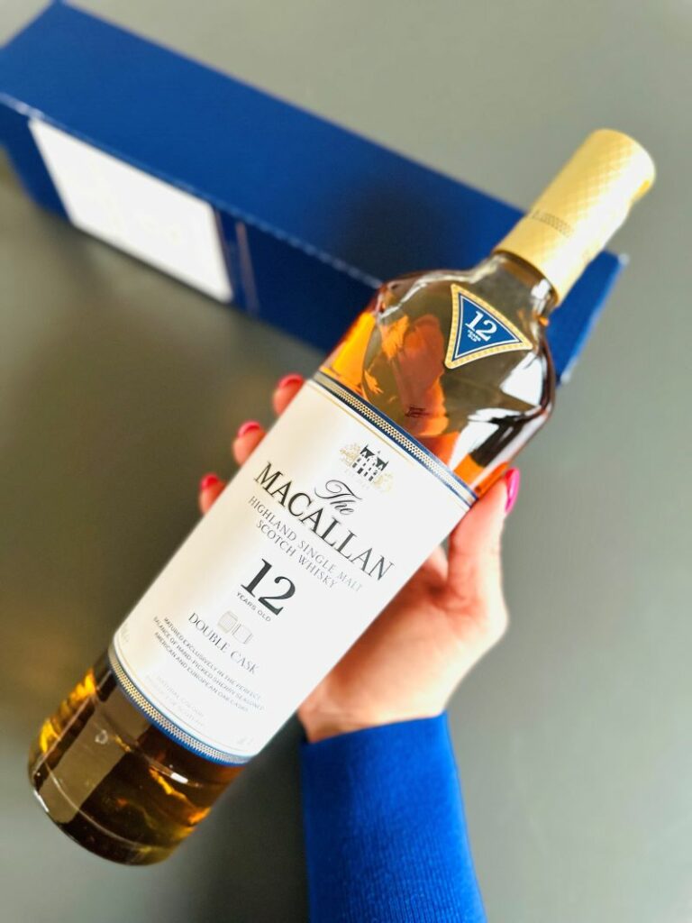 Eine Flasche The Macallan Double Cask 12 Years in der Hand einer Frau.